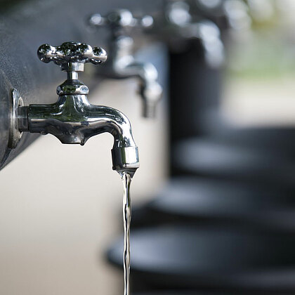 Reihe Wasserhähne mit Waschbecken mit laufendem Wasser